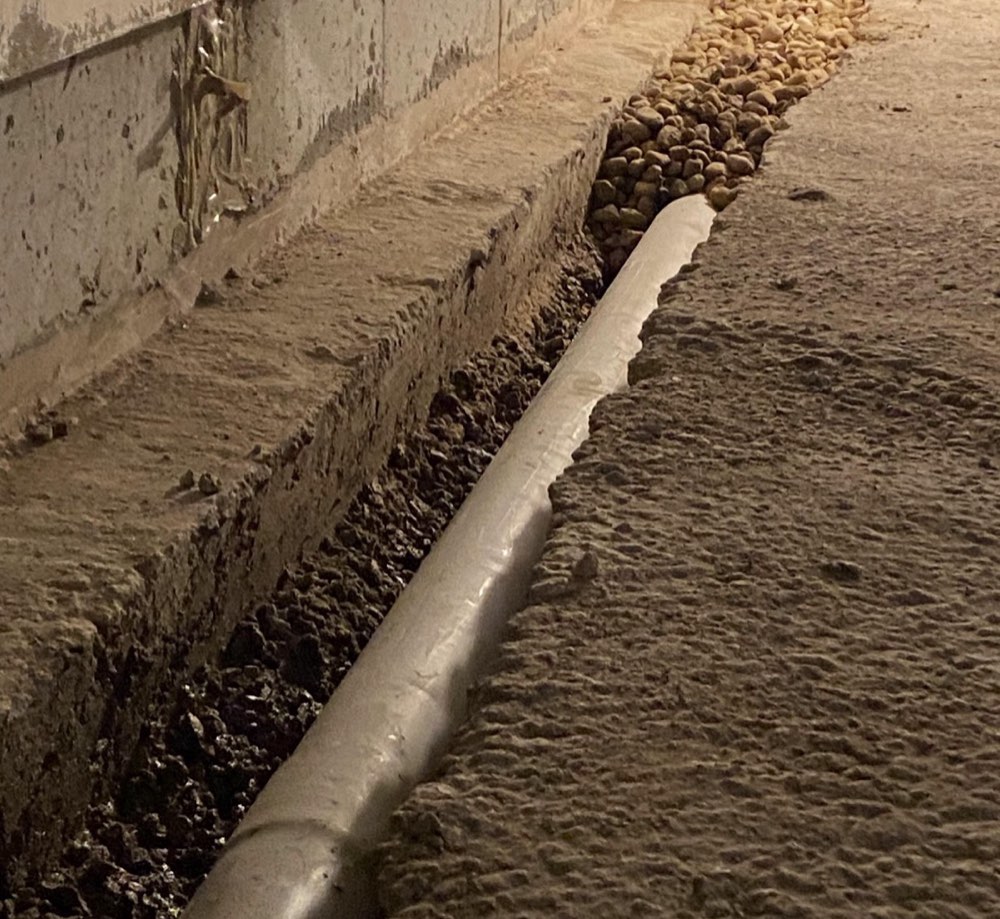 Drain tile trench with perforated PVC and river rock